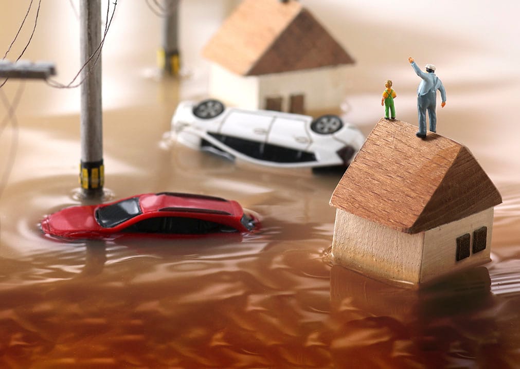 Imagem de casas inundadas por inundações e pessoas à espera de resgate