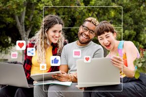 Grupo de amigos diversos aproveitando as redes sociais em laptops ao ar livre. Sorrindo, conectados e compartilhando curtidas e comentários. Diversão e interação nas redes sociais. Foto conceitual de amigos.
